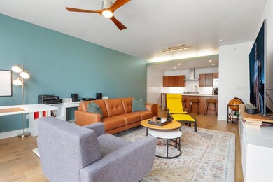 Living room with ceiling fan and light wood-type 