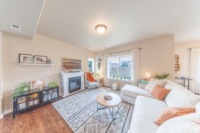 Living area featuring wood finished floors and a glass covered fireplace