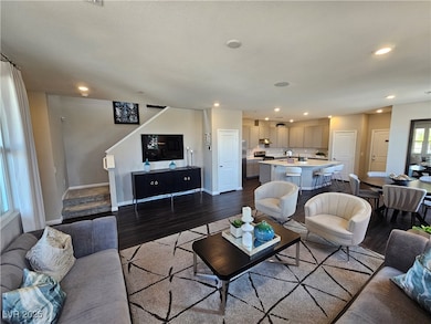 Living area with dark wood-style floors, recessed