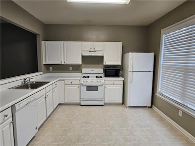 Kitchen featuring light countertops, a sink, white