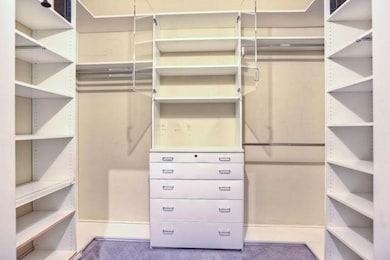 Storage abounds in primary closet, custom storage system