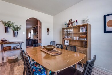 Dining room with an arched doorway and luxury vinyl plank flooring