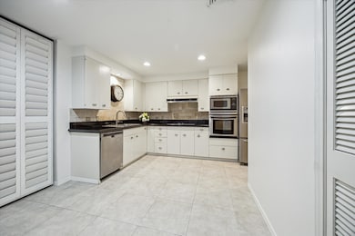 Bright, modern kitchen with white cabinetry, stain