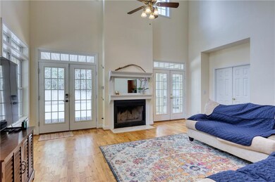 Living room with a high ceiling, ceiling fan, wood