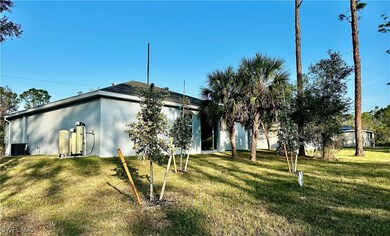 Back of house featuring a yard and cooling unit