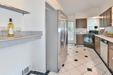 Kitchen featuring appliances with stainless steel finishes, light countertops, and light tile patterned floors