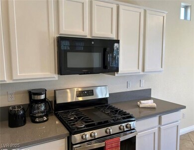 Kitchen featuring stainless steel gas stove, black