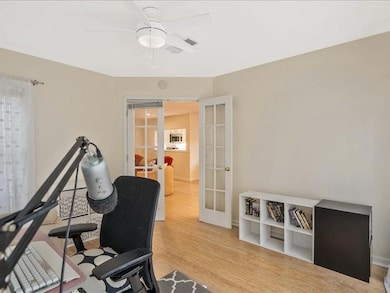 Workout area with french doors, a ceiling fan, wood finished floors, and baseboards