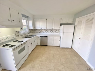 Kitchen with white cabinets, light countertops, wh
