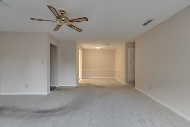 Carpeted spare room featuring baseboards, a textur