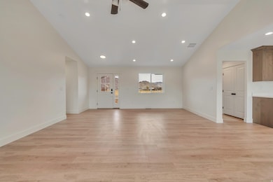 Spare room featuring vaulted ceiling, recessed lighting, light wood finished floors, and ceiling fan