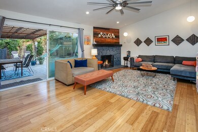 The family room is bathed in natural light and is enhanced by modern recessed lighting, lighted ceiling fan, stone fireplace, sliding glass doors that lead to the backyard and rich hardwood floors.