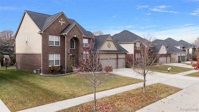 View of front of home featuring brick siding, a front lawn, a garage, concrete driveway, and a residential view