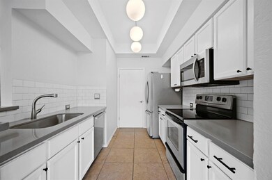 Kitchen with light tile patterned floors, white c