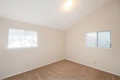 Spare room with carpet floors, vaulted ceiling, a
