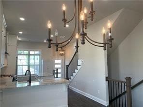 Kitchen with a chandelier, wood finished floors, recessed lighting, and a peninsula