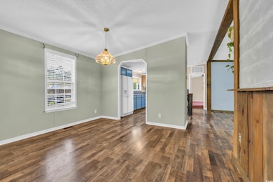 Spare room with an inviting chandelier, dark wood 