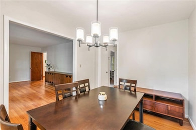 Dining space featuring a chandelier, light wood-style floors, and baseboards