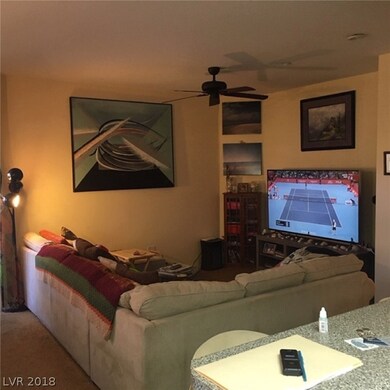 Living room from kitchen. Note ceiling fan.