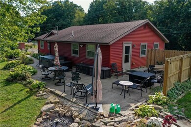 Back of house with hot tub and a patio area