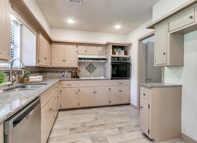 Kitchen featuring sink, tasteful backsplash, black oven, a wealth of natural light, and stainless steel dishwasher