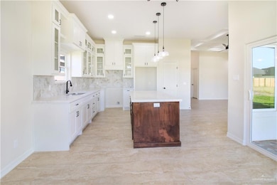 Kitchen with healthy amount of natural light, white cabinets, a kitchen island, and recessed lighting