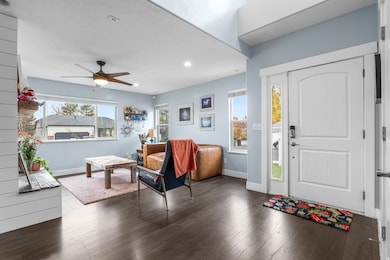 Entrance foyer featuring healthy amount of natural light, dark wood-type flooring, a ceiling fan, and recessed lighting