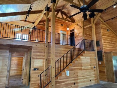 Staircase with wood walls, beamed ceiling, high va