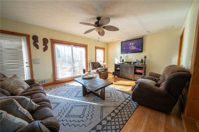 Living room featuring hardwood / wood-style floors, ceiling fan, and a textured ceiling