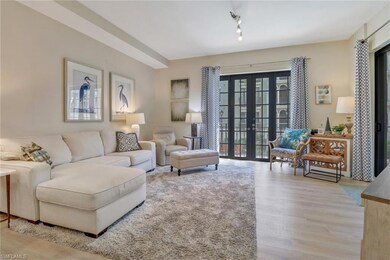 Living room with light hardwood / wood-style floors, french doors, and track lighting