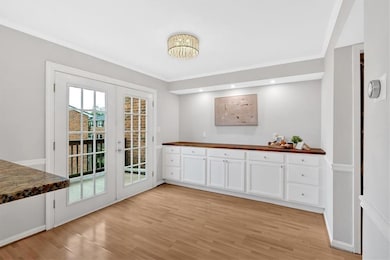 Unfurnished dining area with light wood finished floors, crown molding, and baseboards