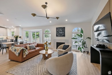 Living room featuring light wood-style floors, a premium fireplace, and recessed lighting