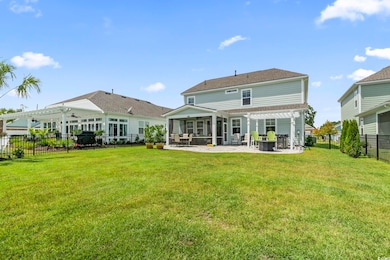 Back of property featuring a pergola, a sunroom, a patio area, and a fenced backyard