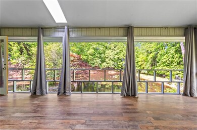 Screened in porch off living area and primary suite overlooking the shared pond