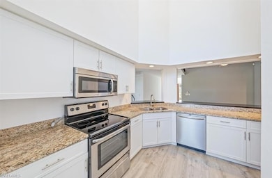 Kitchen with white cabinets, light wood-type floor