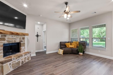 Sitting room with ceiling fan, a fireplace, and da