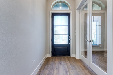 Entryway featuring wood finished floors and french doors