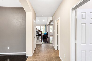 As you enter the house, you see the long, tiled hallway leading to the living room.  The dining room is on your left.  The office is on your right.