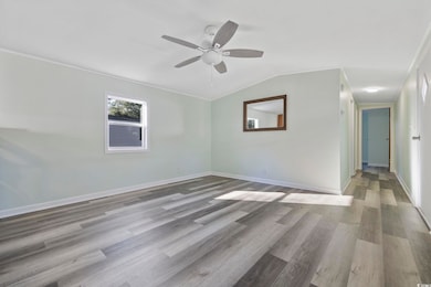 Empty room featuring ceiling fan, lofted ceiling, 