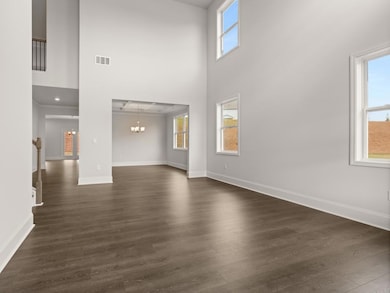 Westerly front entryway into two-story foyer with hardwood-like flooring