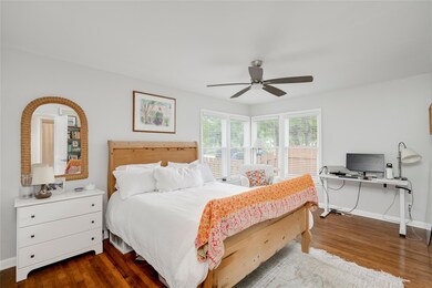 Bedroom with dark wood finished floors, baseboard