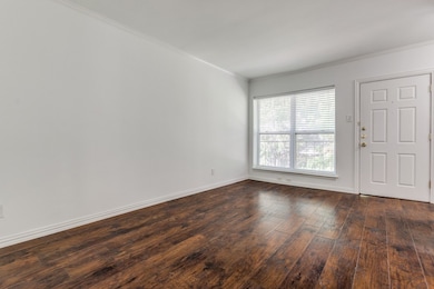 Entrance foyer with dark wood-style flooring and ornamental molding
