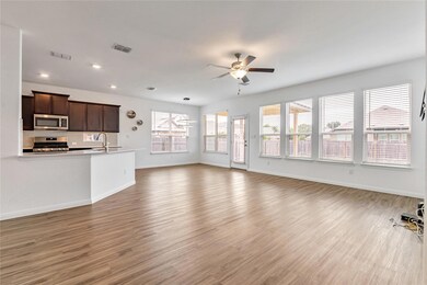 Unfurnished living room featuring ceiling fan, li