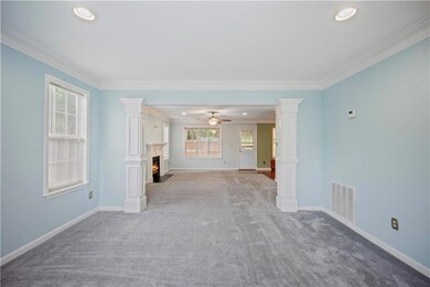 Stairs featuring crown molding, a fireplace with f
