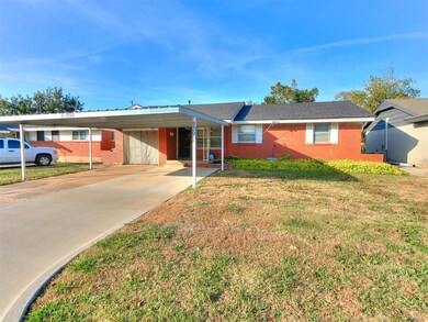 Single story home with a front yard and a carport