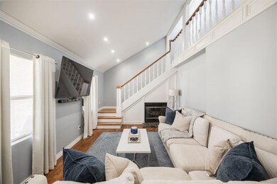 Living room with stairs, ornamental molding, wood 