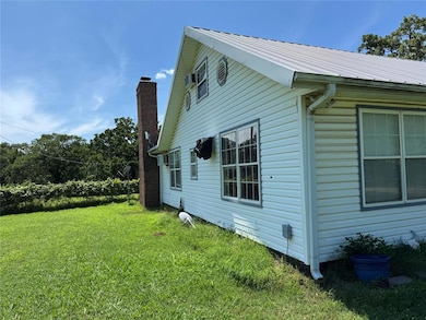 View of home's exterior with a yard, a metal roof, and a chimney
