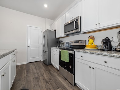 Kitchen with light stone countertops, stainless st