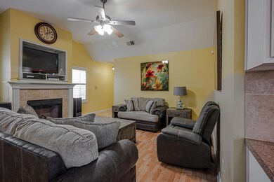 Living room with a fireplace, vaulted ceiling, lig