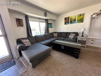 Carpeted living room featuring a textured ceiling